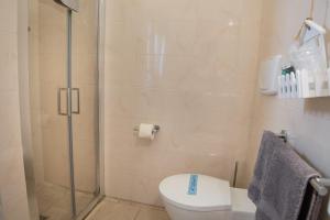 La salle de bains est pourvue de toilettes et d'une douche en verre. dans l'établissement Antica Masseria Ficazzana - Tenuta, à Marina di Pescoluse
