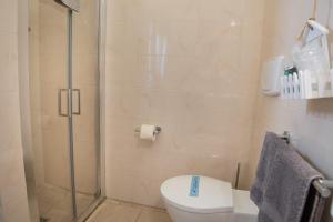 a bathroom with a toilet and a glass shower at Antica Masseria Ficazzana - Tenuta in Marina di Pescoluse