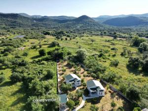une vue aérienne sur une maison avec des montagnes en arrière-plan dans l'établissement Oikies Verde III-F, à Perdika