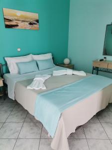 a large bed in a room with a blue wall at LASKARINA'S HOUSE in Skala Potamias