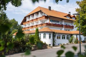 a large white building with an orange roof at Sattelbogener Hof in Traitsching