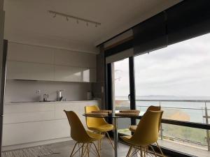 a kitchen with a table and chairs and a large window at Piso en la Playa in Ribeira