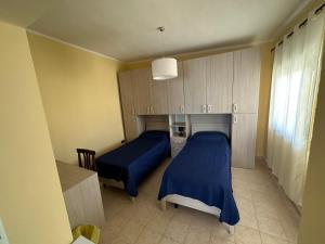 um quarto com 2 camas, uma secretária e armários em Baia dei turchi locazione turistica em Realmonte