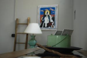 een tafel met een lamp en een plaat met een laptop bij POLLONE, TERRAZZA37 in Pollone