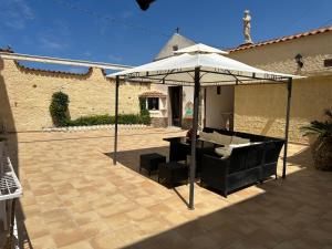 patio con ombrellone e divano sotto di Baia dei turchi locazione turistica a Realmonte