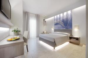 Un dormitorio con una cama y una mesa con una bandeja de fruta en Hotel Ristorante Sogno, en San Felice del Benaco