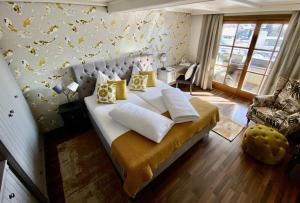 a bedroom with a large bed with yellow pillows at Landhotel Lindenhof in Feld am See