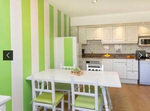cocina con mesa blanca y rayas verdes y blancas en Apartamento familiar, en Torroella de Montgrí