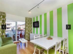a living room with a green and white striped wall at Apartamento familiar in Torroella de Montgrí
