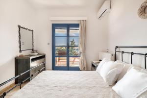 1 dormitorio con 1 cama y puerta a un balcón en Nefeli's House, en Souvala