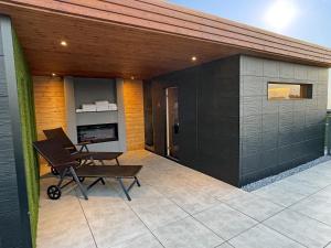 an outdoor patio with a chair and a fireplace at Fisher's Inn in Zingst