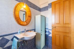 baño con lavabo, espejo y nevera en Nefeli's House, en Souvala