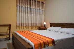 a bedroom with a bed with an orange blanket on it at Paramount Residence - 7 in Peliyagoda