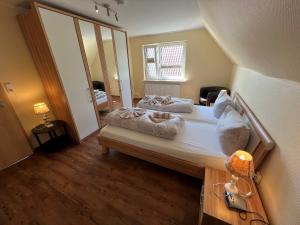 een slaapkamer met een groot bed en een grote spiegel bij Kugelbake Bantje Wohnung 2 in Borkum