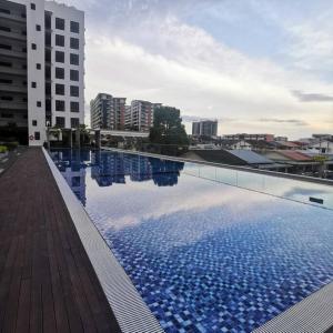 een groot zwembad in een stad met gebouwen bij Elegant Armadale Homestay With Pool at Galacity in Kuching