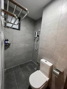 a bathroom with a white toilet and a shower at Elegant Armadale Homestay With Pool at Galacity in Kuching
