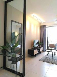 un soggiorno con specchio e tavolo di Elegant Armadale Homestay With Pool at Galacity a Kuching