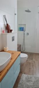 a white bathroom with a sink and a toilet at הבית של כנרת in H̱efẕi Bah