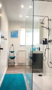 a bathroom with a shower and a blue rug at Moderne helle Ferienwohnung in Remagen