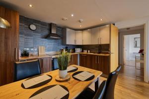 a kitchen and dining room with a wooden table and chairs at Lovely Central 1-Bedroom Flat with a View, Ideal Getaway in Liverpool
