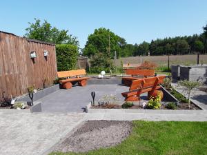 een patio met banken en bloemen in een tuin bij Haus Sperling in Bad Zwischenahn