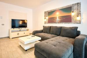 uma sala de estar com um sofá e uma televisão em Silverbay - Indoor Pool & Spa Resort em Mamaia Nord – Năvodari
