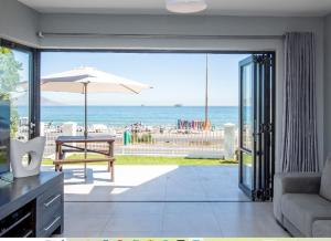 a living room with a view of the beach at Cap du Mont in Bloubergstrand