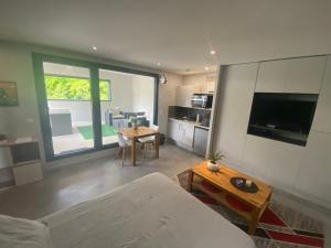 uma sala de estar com um sofá e uma mesa em Appartement avec Terrasse couverte - La Motte-Servolex em La Motte-Servolex