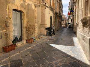 an alley with a motorcycle parked on the side of a building at Casa Mirabella in Siracusa