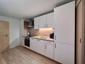 a kitchen with white cabinets and a sink at Kiblerhof in Russbach am Pass Gschütt