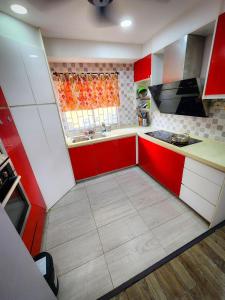 eine Küche mit roten und weißen Schränken und einem Fenster in der Unterkunft 3 Bedrooms with Pool Hanan Residence Ketumbar Heights Condominium in Cheras