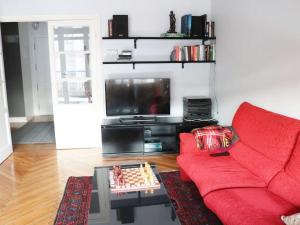 sala de estar con sofá rojo y TV en Apartamento Miramar, en Hondarribia