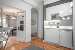 a kitchen with white cabinets and a dining room at Apartamento Miramar in Hondarribia +26 photos