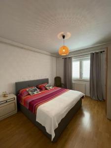 - une chambre avec un grand lit et un lustre dans l'établissement Mare i Kate Apartmani, à Tribunj