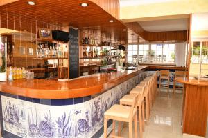 un bar en un restaurante con muchas mesas y sillas en Hotel Vista Sol en Cala Ratjada