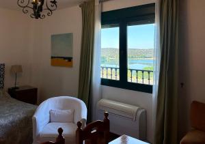 a bedroom with a bed and a chair and a window at Doña Ruidera in Ruidera