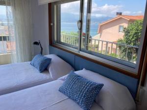 een kamer met 2 bedden en een groot raam bij Casa a 2 minutos andando a la playa de Panxón in Nigrán