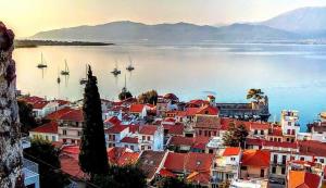 a town with red roofs and a large body of water at Sideroporta castle Náfpaktos in Nafpaktos