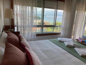 a bed in a bedroom with a large window at Casa a 2 minutos andando a la playa de Panxón in Nigrán