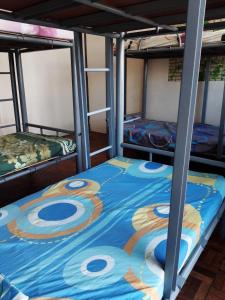 two bunk beds in a room with a blue blanket at Mang Ben Dormitory Pasay in Manila
