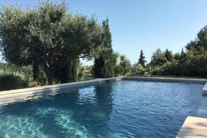 a swimming pool with a tree in the background at Provencal Villa with Stunning Views of the Sea and Mountains in Le Bar-sur-Loup