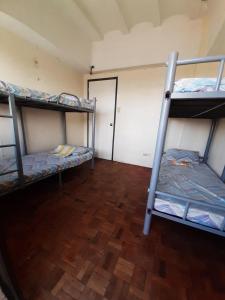 a room with three bunk beds and a hallway at Mang Ben Dormitory Pasay in Manila