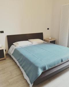 una camera da letto con un grande letto con una coperta blu di Asti - La casa di ringhiera ad Asti