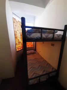 two bunk beds in a small room with a window at Mang Ben Dormitory Pasay in Manila