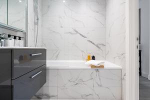 Baño blanco con bañera y lavamanos en Hemel Apartments- Riverside Retreat en Hemel Hempstead
