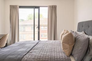 a bedroom with a bed and a large window at Hemel Apartments- Riverside Retreat in Hemel Hempstead