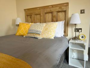 a bed with pillows and a wooden headboard in a bedroom at Bay Horse in York