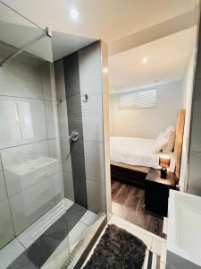 a bathroom with a glass shower and a bed at Urban Retreat with a View in Windhoek