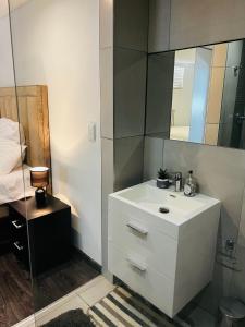 a bathroom with a white sink and a mirror at Urban Retreat with a View in Windhoek