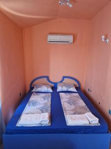 プリモルスコにあるDara Hotelのオレンジ色の壁の小さな部屋のベッド2台
